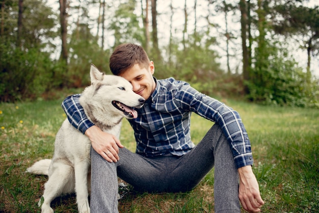 Chico guapo en un parque de verano con un perro