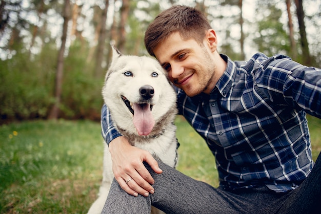 Chico guapo en un parque de verano con un perro