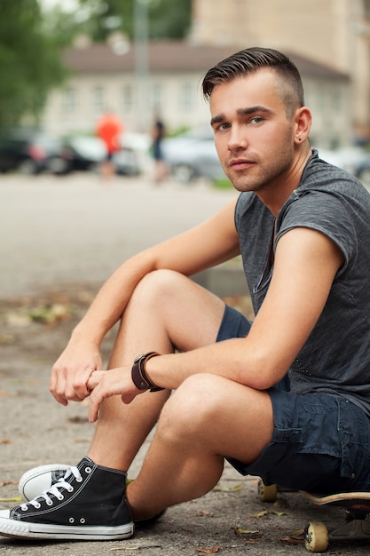 Foto gratuita chico guapo sentado en la calle