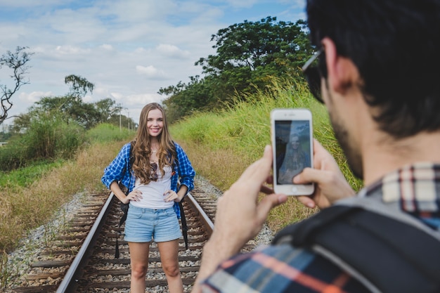 Foto gratuita chico haciendo foto de novia en vías de tren