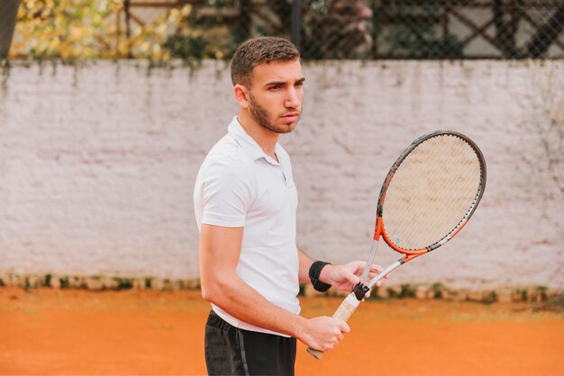 Chico joven atlético jugando al tenis