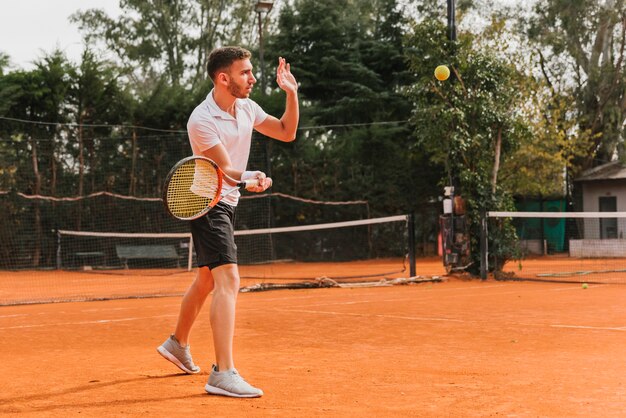 Chico joven atlético jugando al tenis