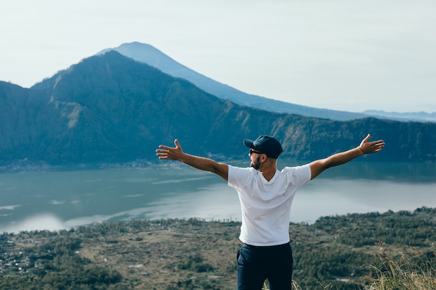 chico joven con barba y una mochila posando en la selva con una gorra