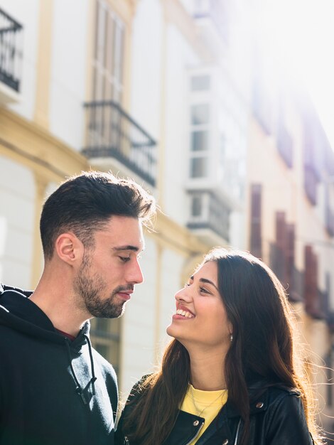 Chico joven cerca de señora feliz en la calle