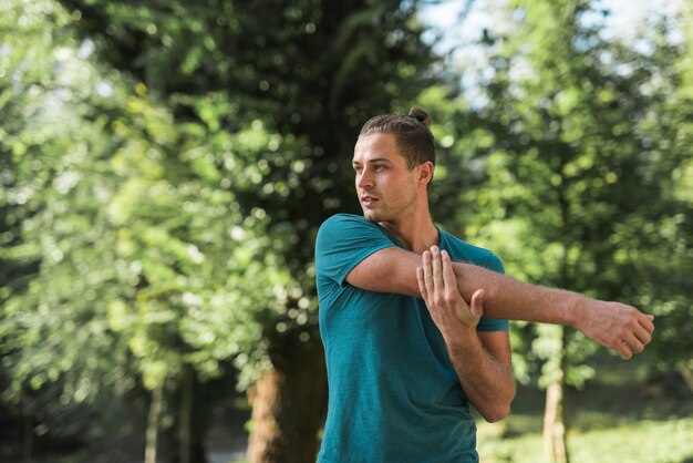 Chico joven estirando en el parque