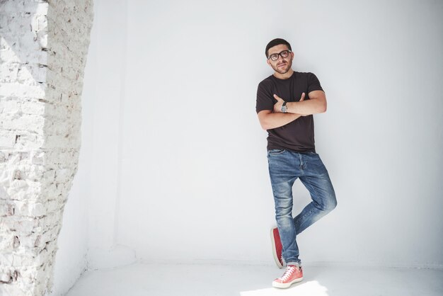 Chico joven inconformista con gafas riendo felizmente aislado en blanco