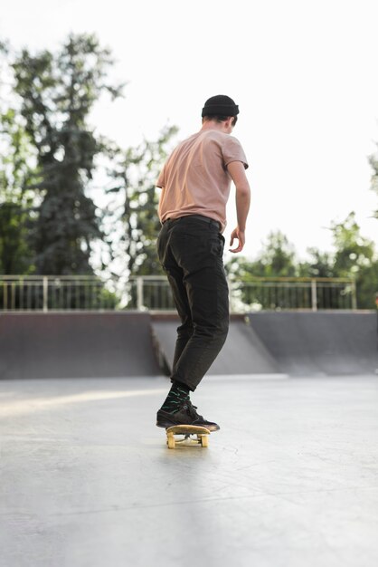 Chico joven patinando con patineta en la calle