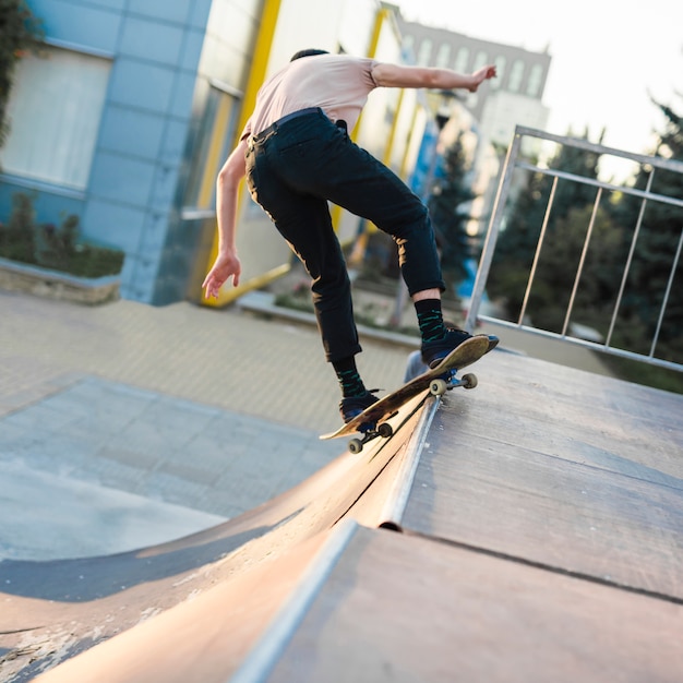 Foto gratuita chico joven patinando con patineta en la calle