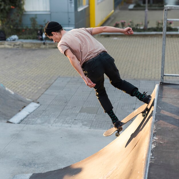 Chico joven patinando con patineta en la calle