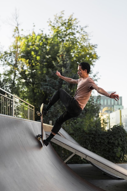 Foto gratuita chico joven patinando con patineta en la calle