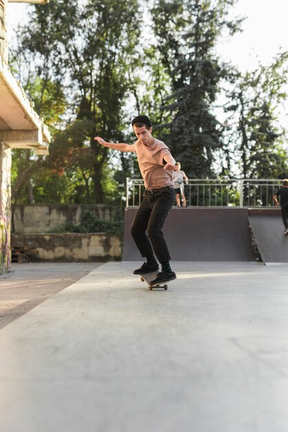 Chico joven patinando con patineta en la calle