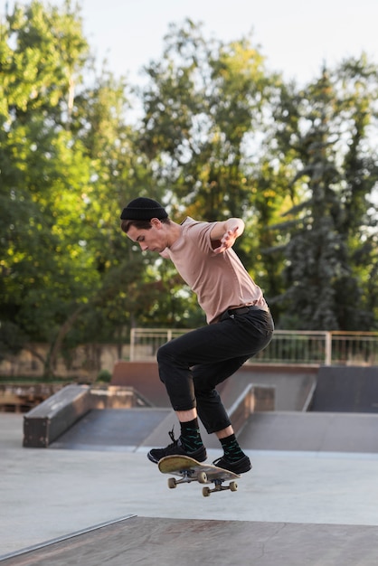 Foto gratuita chico joven patinando con patineta en la calle