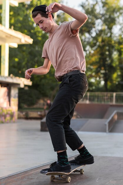 Chico joven patinando con patineta en la calle