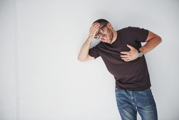 Un chico joven en ropa casual se aferra al corazón y la cabeza