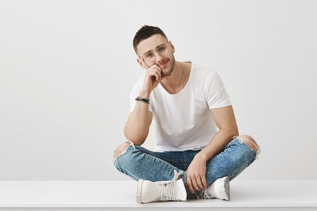 Foto gratuita chico joven sonriente con gafas posando