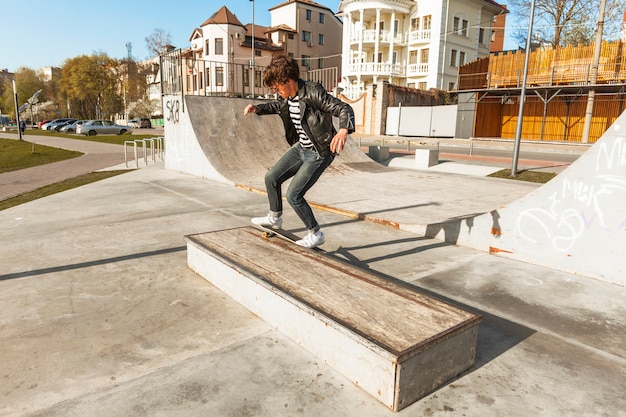 Chico joven con su monopatin en la pista de skate