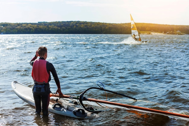 Foto gratuita chico joven con tabla de kitesurf