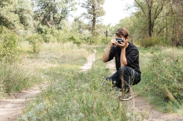 Chico joven tomando fotos en la naturaleza con espacio de copia