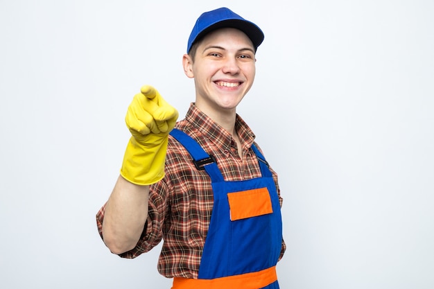 Chico de limpieza joven con uniforme y gorra con guantes aislado en la pared blanca