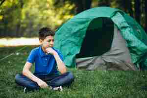 Foto gratuita chico lindo que acampa en el bosque