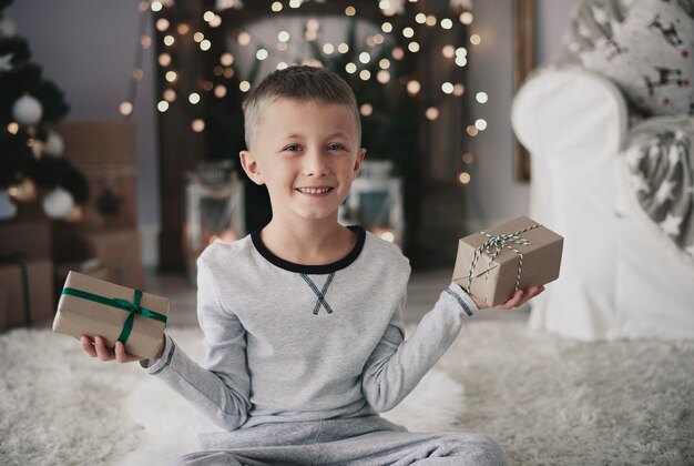 Chico lindo con regalos mirando a cámara