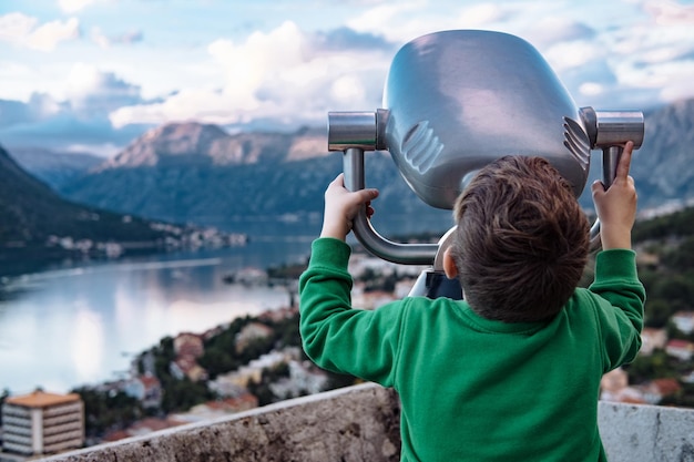 Chico mirando a través de binoculares en la ciudad de Kotor Montenegro