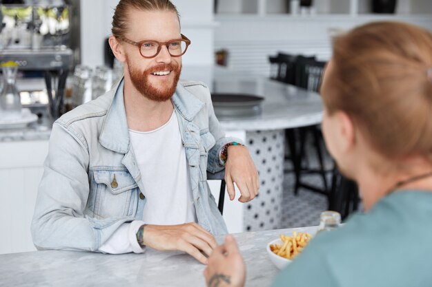 Chico de moda hipster sentado con una mujer en el café