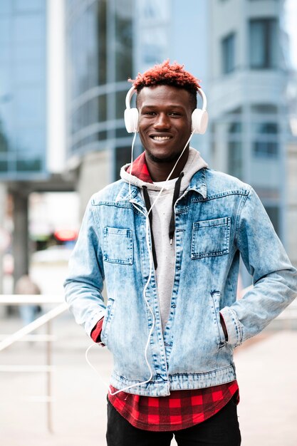 Foto gratuita chico de moda de tiro medio con auriculares posando