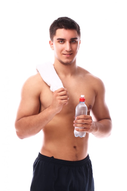 Chico musculoso con toalla y botella de agua