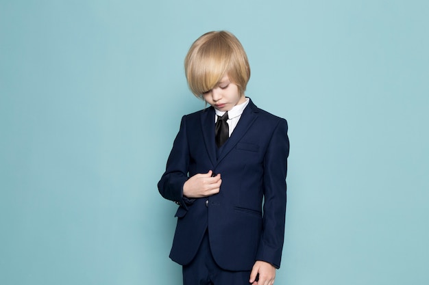 Un chico de negocios lindo vista frontal en traje clásico azul posando moda de trabajo empresarial