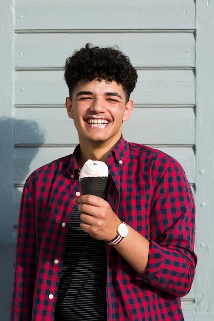 Chico negro riendo en camisa a cuadros con helado