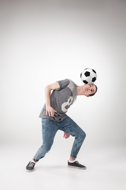 chico con pelota de futbol en gris