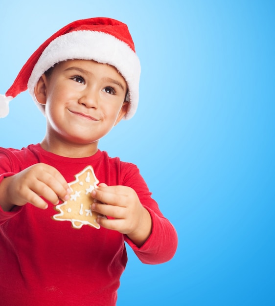 Chico pequeño con una galleta de árbol