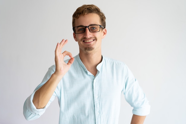 Chico positivo amable que aprueba anteojos nuevos.