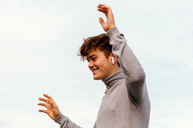 Chico de primer plano al aire libre con auriculares