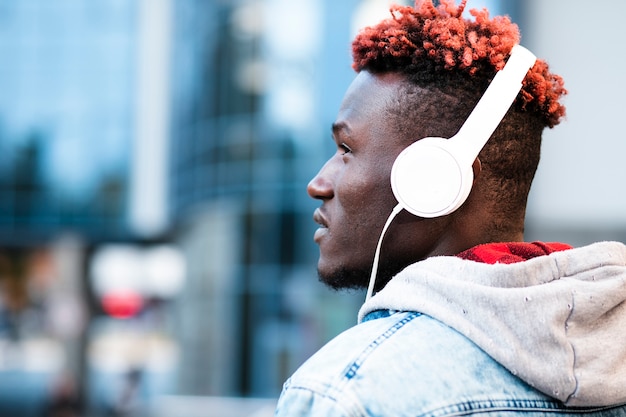 Foto gratuita chico de primer plano con auriculares mirando a otro lado