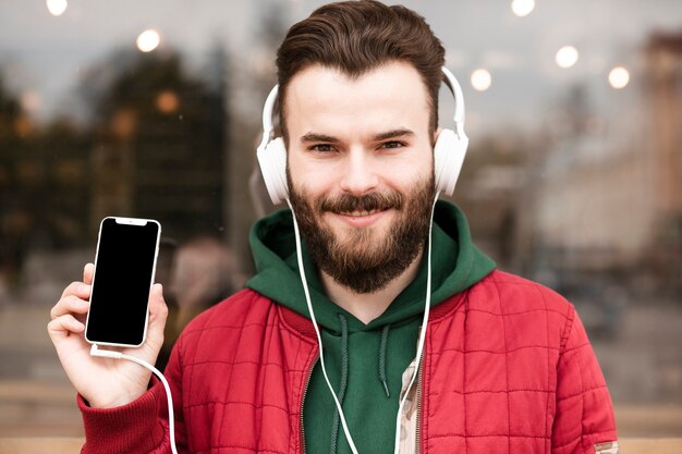 Foto gratuita chico de primer plano con auriculares con smartphone