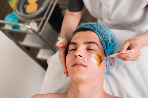 Chico recibiendo tratamiento facial en salón de belleza