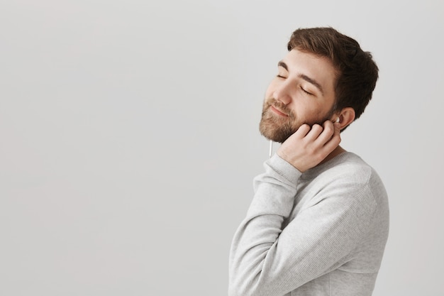 Chico romántico lindo disfrutando de escuchar música en auriculares