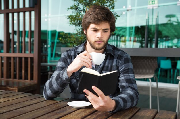 Chico serio emocionado con historia de libro interesante