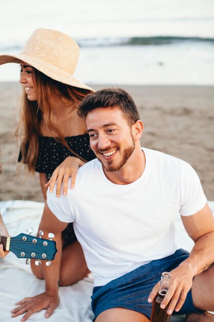 Chico sonriendo a sus amigos en la playa