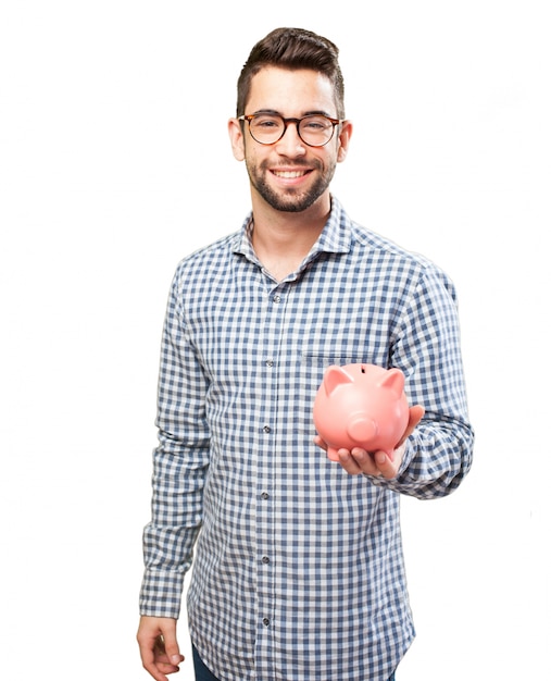 Foto gratuita chico sonriente con gafas mostrando una hucha