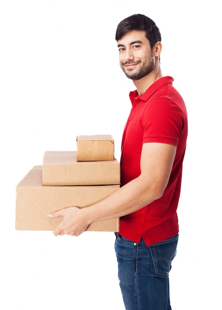 Foto gratuita chico sonriente sujetando algunas cajas