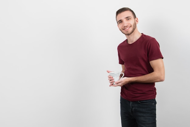 Chico sosteniendo una taza de café y una sonrisa