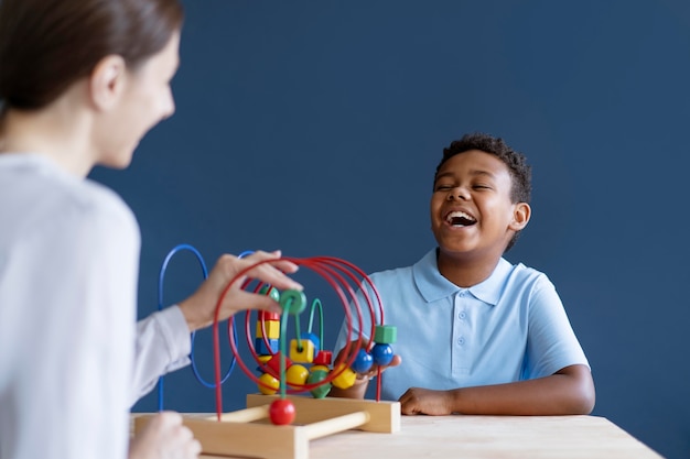 Foto gratuita chico tener una sesión de terapia ocupacional con un psicólogo