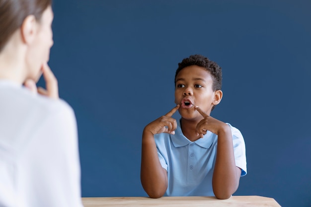 Foto gratuita chico tener una sesión de terapia ocupacional con un psicólogo