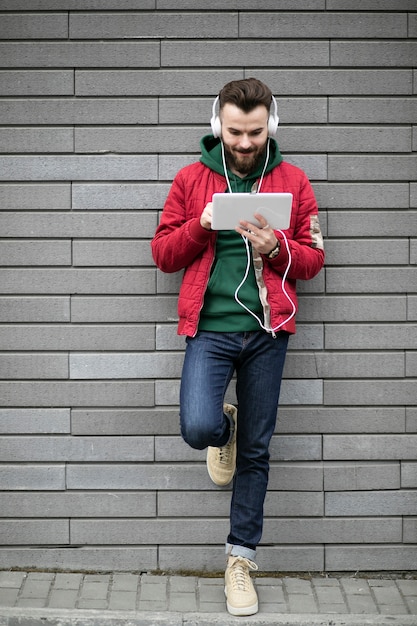 Foto gratuita chico de tiro completo con auriculares y tableta