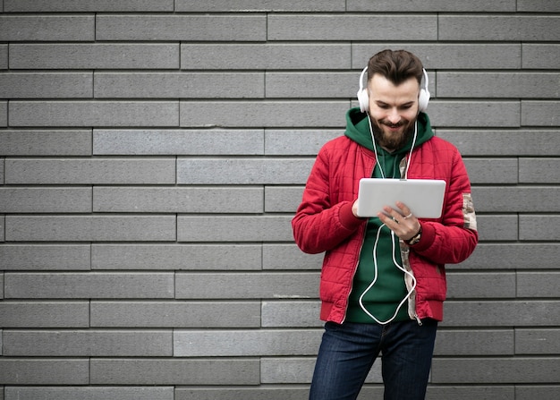 Chico de tiro medio con auriculares y tableta