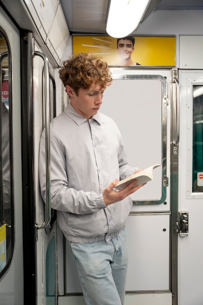 Chico de tiro medio leyendo en transporte público