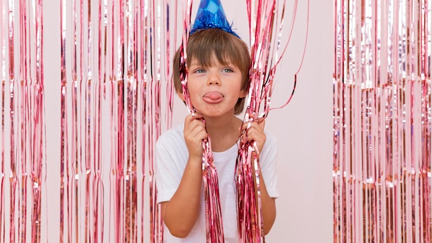 Foto gratuita chico de tiro medio con sombrero de fiesta azul